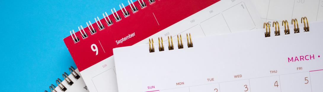 pile of calendars in front of a bright blue background